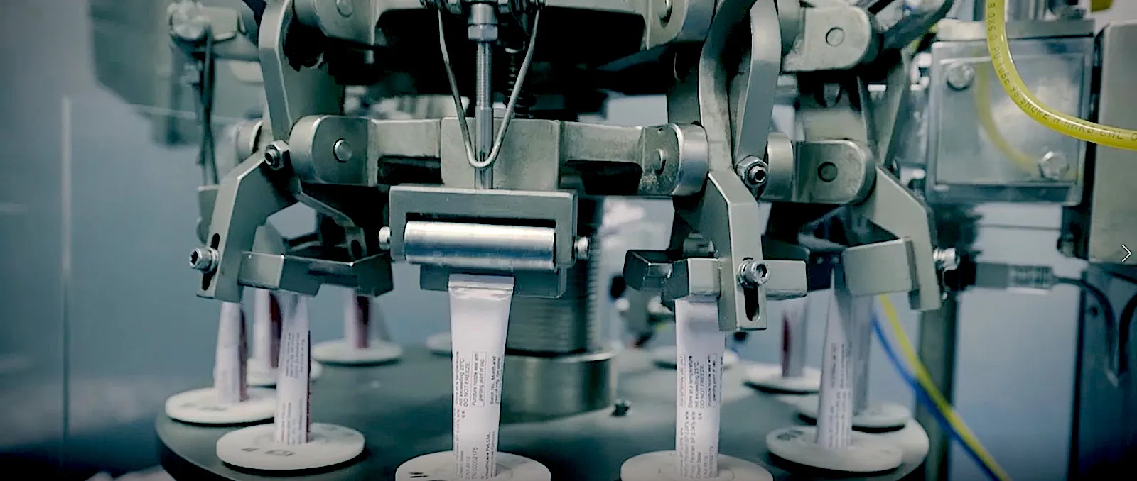 pharmaceutical quality control laboratory with scientists in blue coats examining medicine, modern equipment, professional photography